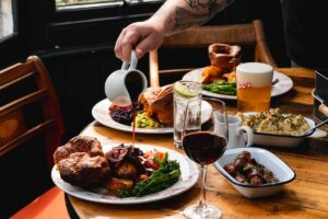 person pouring gravy over Yorkshire pudding
